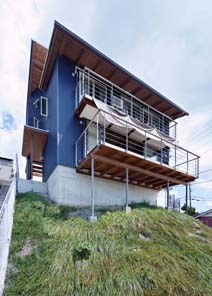 瀬戸内海を見下ろす斜面に建つ、松尾さん設計の住宅。海を望む南側に軒を張り出した屋根と大きな窓をつけ、リビングダイニングを配置している（写真提供・松尾設計室）。