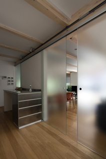 リビングとキッチンを隔てるドアをはじめ、建具にはガラスを多用。光の反射や透過で素材感が際立つインテリアだ。