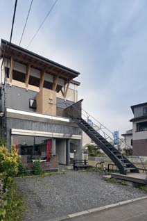 浅野邸の1階はライブハウス。張り出した庇が目を引く住居には、末広がりの美しい曲線を見せるオリジナルデザインの鉄製階段を上っていく。