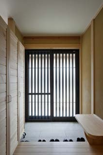 伝統的な日本家屋らしい広い玄関には、高性能断熱引き戸が採用された。右手のベンチは奥様が靴を脱ぎ履きする際に腰掛けられるほか、荷物置き場としても活躍。