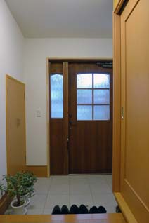 エコガラスがはめ込まれたチーク材の玄関扉。もちろん断熱仕様。