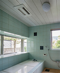 タイル張りの浴室は東と南の２面採光。天井の浴室暖房がヒートショックの不安を解消する