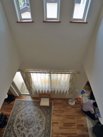 吹抜けを２階から見おろす。３列並んだFIX窓にも遮熱型Low-Eガラスを採用し、大空間を高気密・高断熱化。