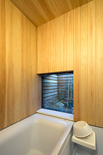木の香ただよう浴室の窓外に坪庭がのぞく。窓ガラスはすべて壁内に引き込めるようになっている